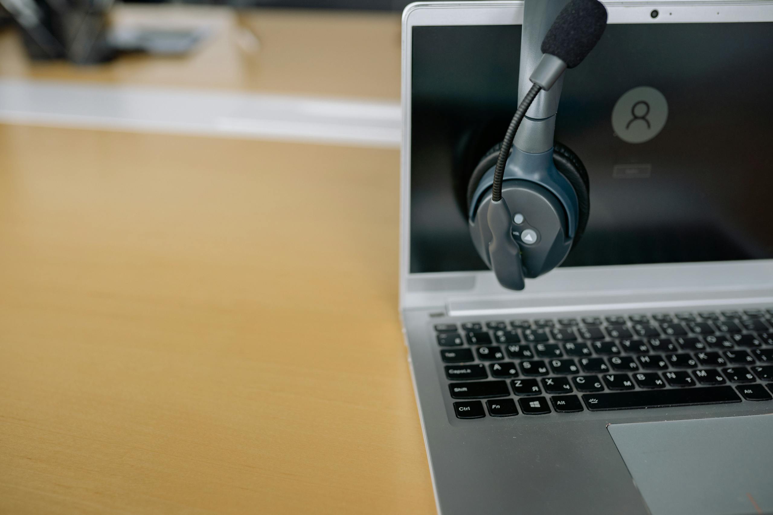 Close-up of wireless headset on laptop screen, ideal for communication tech visuals.